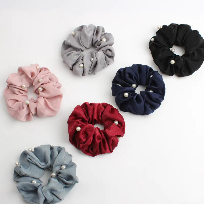 cloth hair accessories collection featuring six stylish scrunchies in various colors and pearl accents.